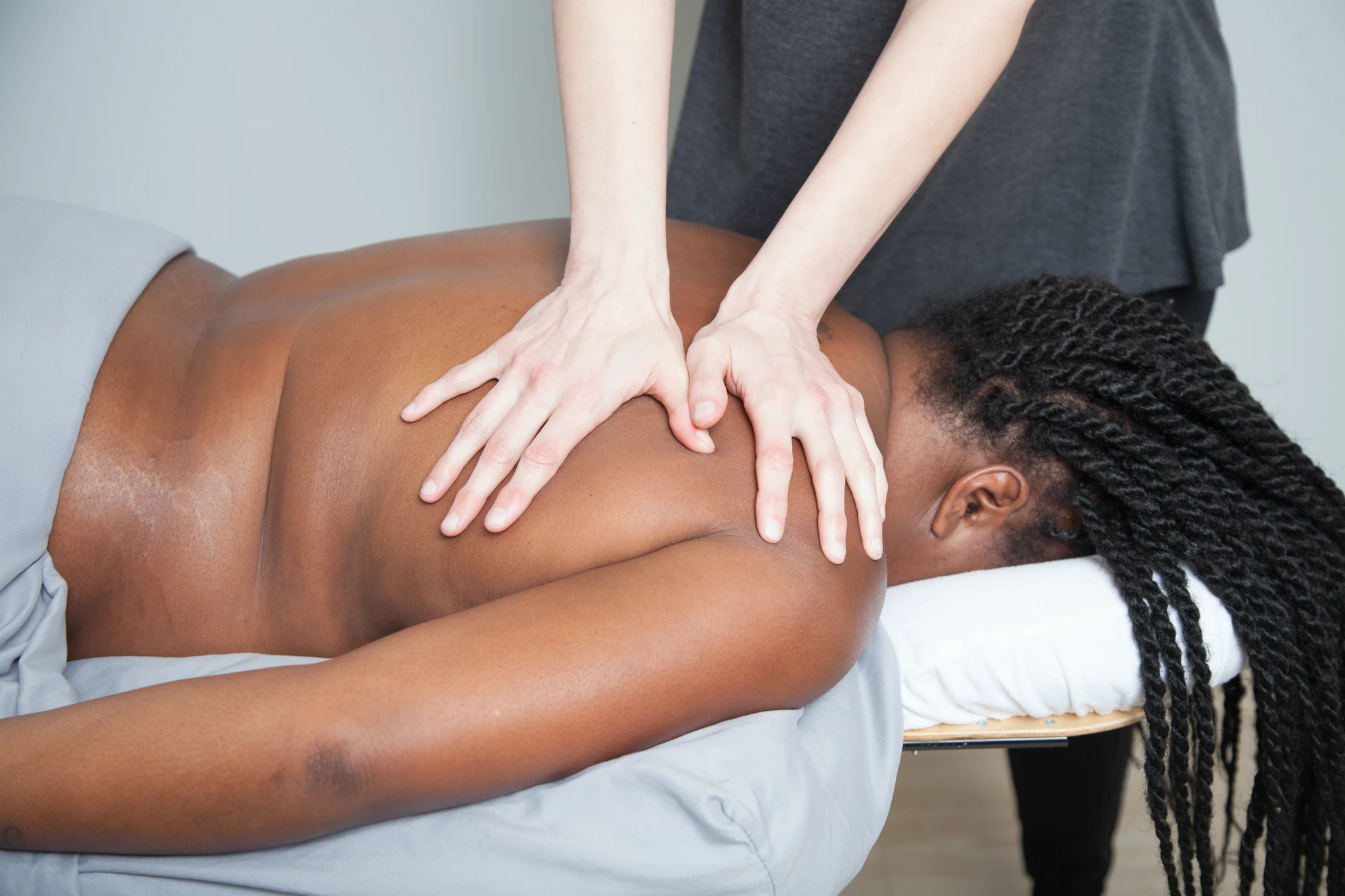 Woman with long braids receiving deep tissue sports massage